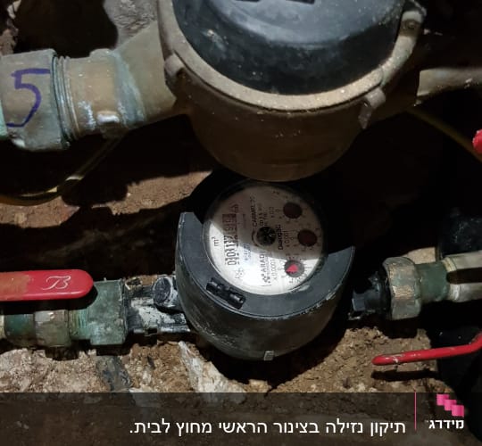 מונה מים עם צינורות וברזים אדומים